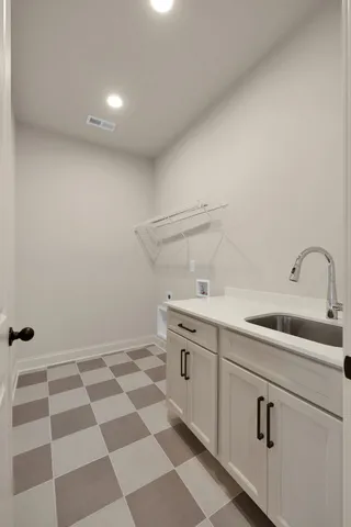 a kitchen with a sink a refrigerator and cabinets