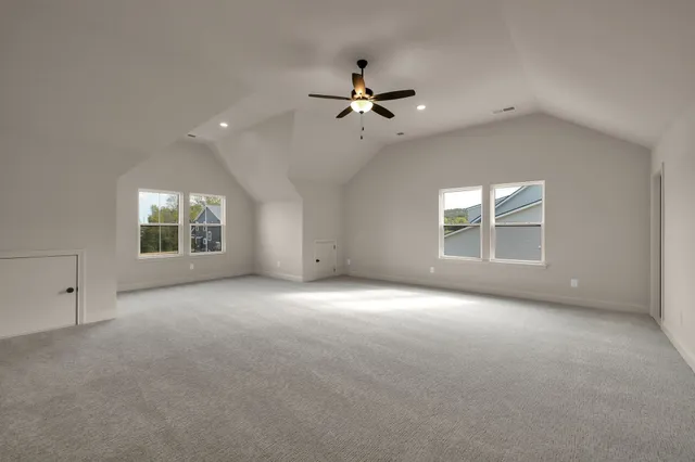 an empty room with windows and ceiling fan