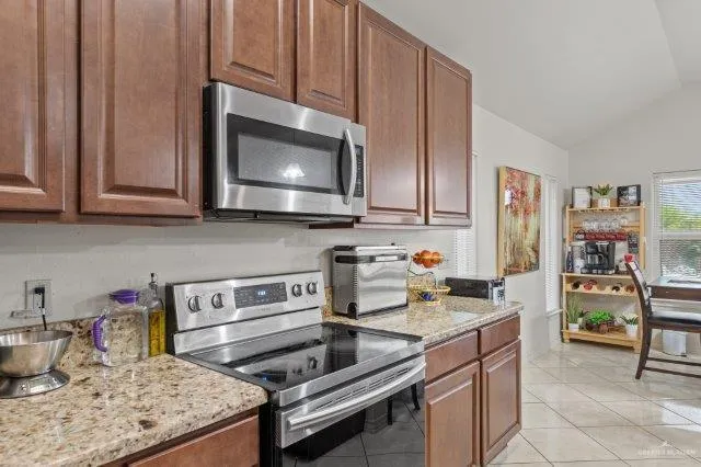 a kitchen with stainless steel appliances granite countertop a stove and a microwave
