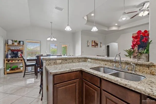 a kitchen with a sink a counter space appliances and a dining table