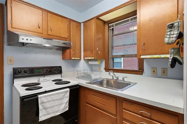 a kitchen with stainless steel appliances a stove a sink and a microwave