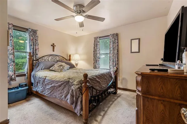 a bedroom with a bed window and a flat screen tv