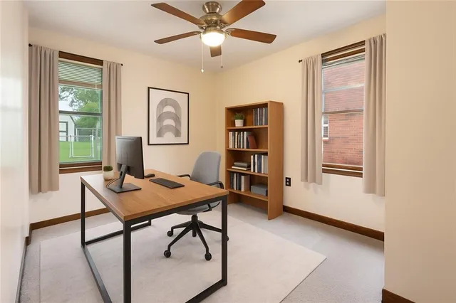 a view of a workspace with furniture and a window