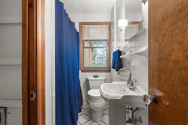 a bathroom with a granite countertop sink toilet and mirror