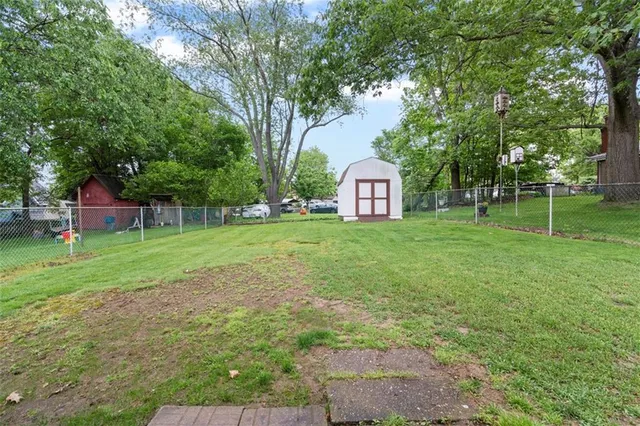 a view of a house with a big yard and large trees