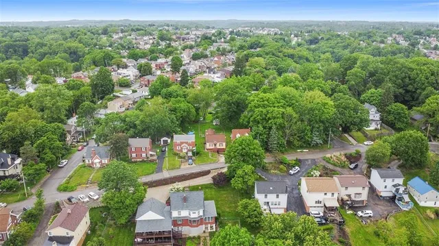 an aerial view of residential houses with outdoor space and trees