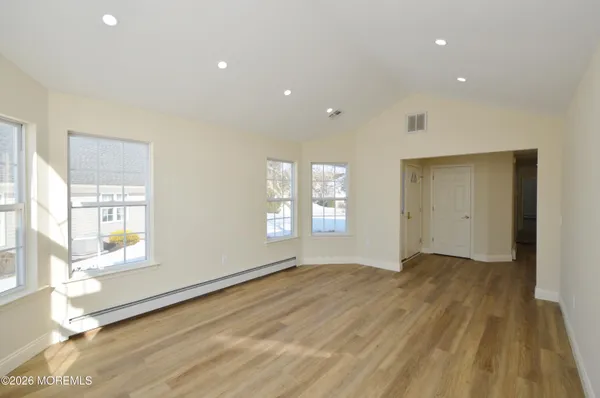 a view of a hallway with wooden floor and a window