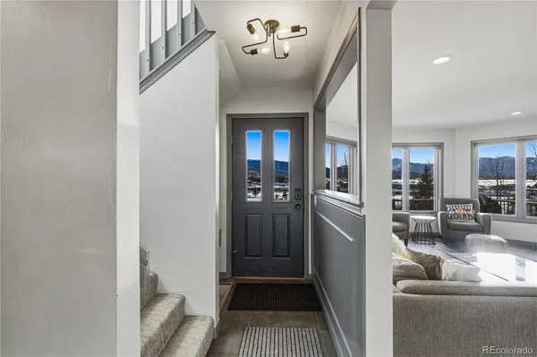 a view of a hallway with furniture and chandelier