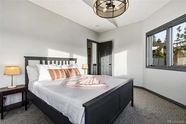 a bedroom with a bed and a chandelier