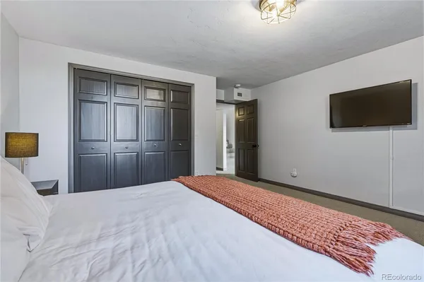 a bedroom with a bed and a flat screen tv