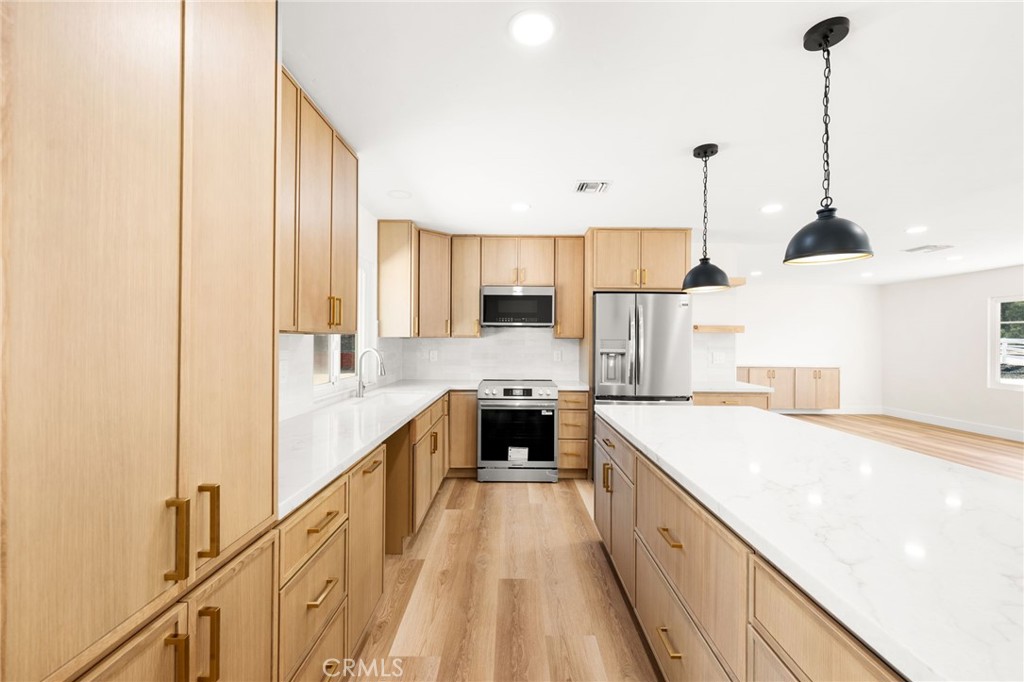 2060 South Grade Road Alpine, CA 91901 - Photo 14 of 69 a large kitchen with a large counter top a sink a stove a refrigerator and cabinets