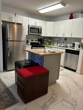 a kitchen with stainless steel appliances granite countertop a refrigerator sink and microwave