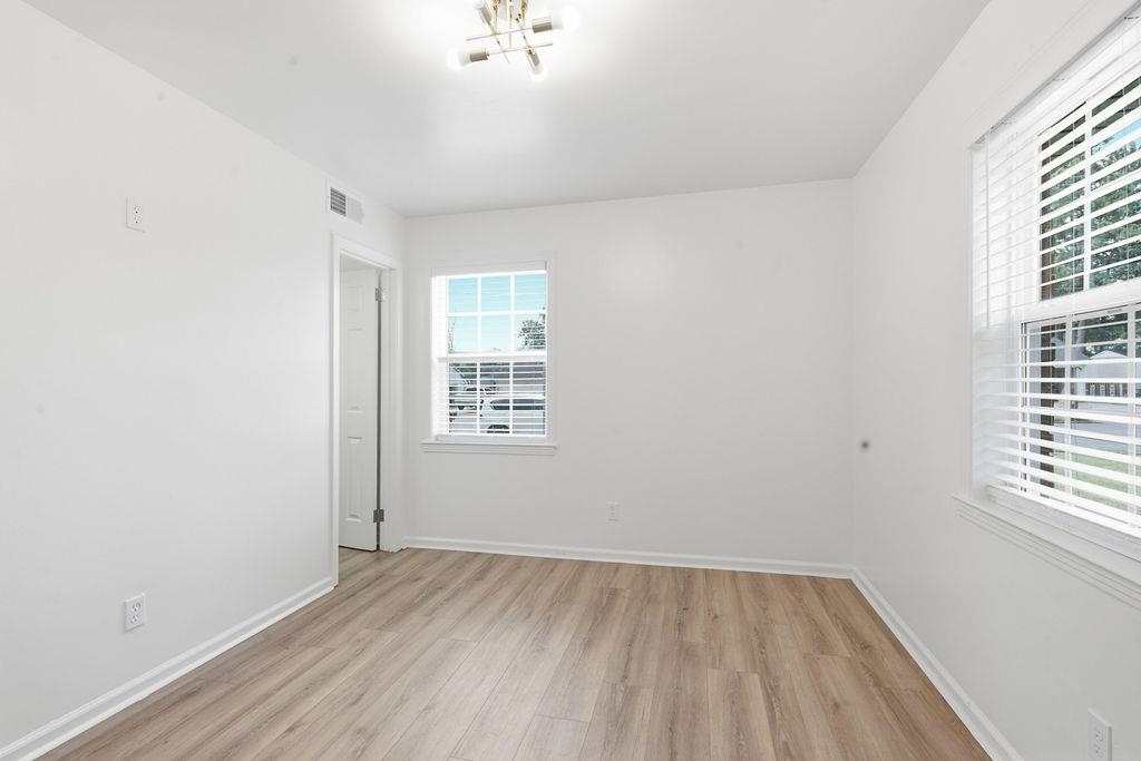 1304 Winfield Road Memphis, TN 38116 - Photo 14 of 19 Wood-finish flooring, white walls, and a contemporary flush-mount light fixture