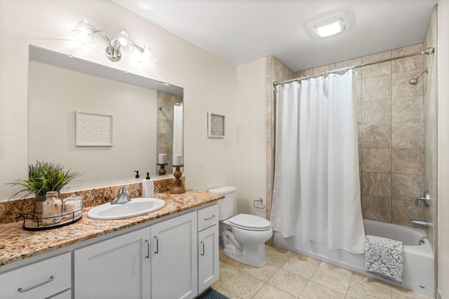 708 Frederick Street, Unit 204 Santa Cruz, CA 95062 - Photo 13 of 28 a bathroom with a granite countertop sink a toilet a mirror and shower