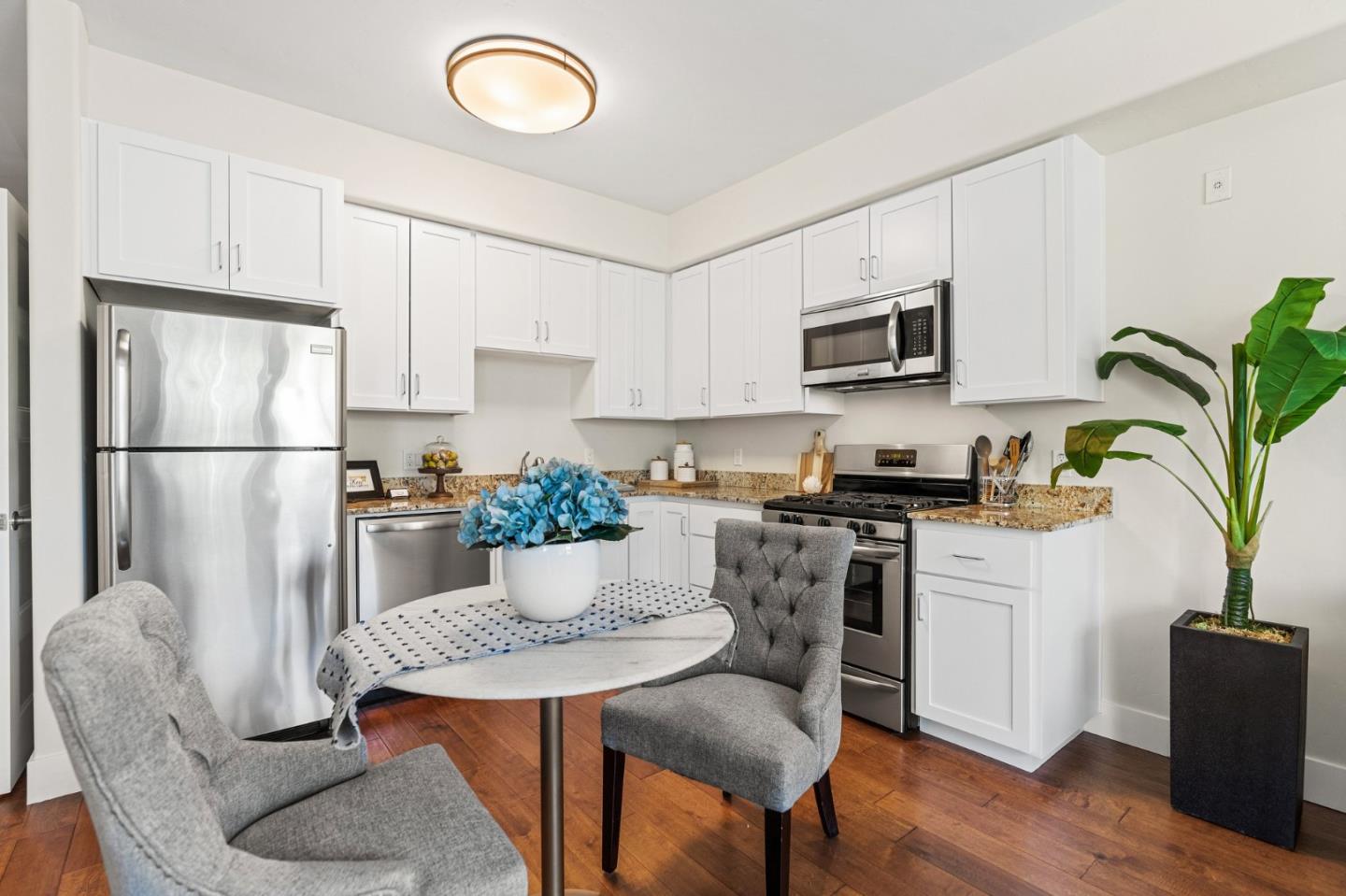 708 Frederick Street, Unit 204 Santa Cruz, CA 95062 - Photo 5 of 28 a kitchen with stainless steel appliances granite countertop a refrigerator a stove a sink a dining table and chairs with wooden floor