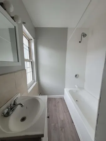 a bathroom with a tub sink and mirror