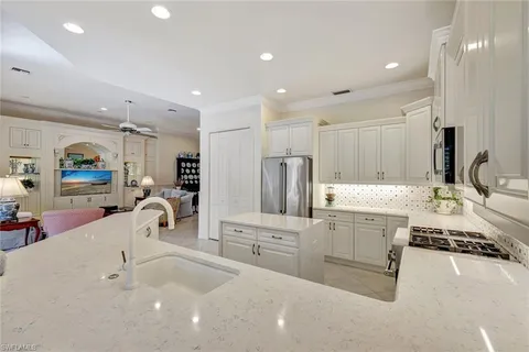 a kitchen with sink and white cabinets