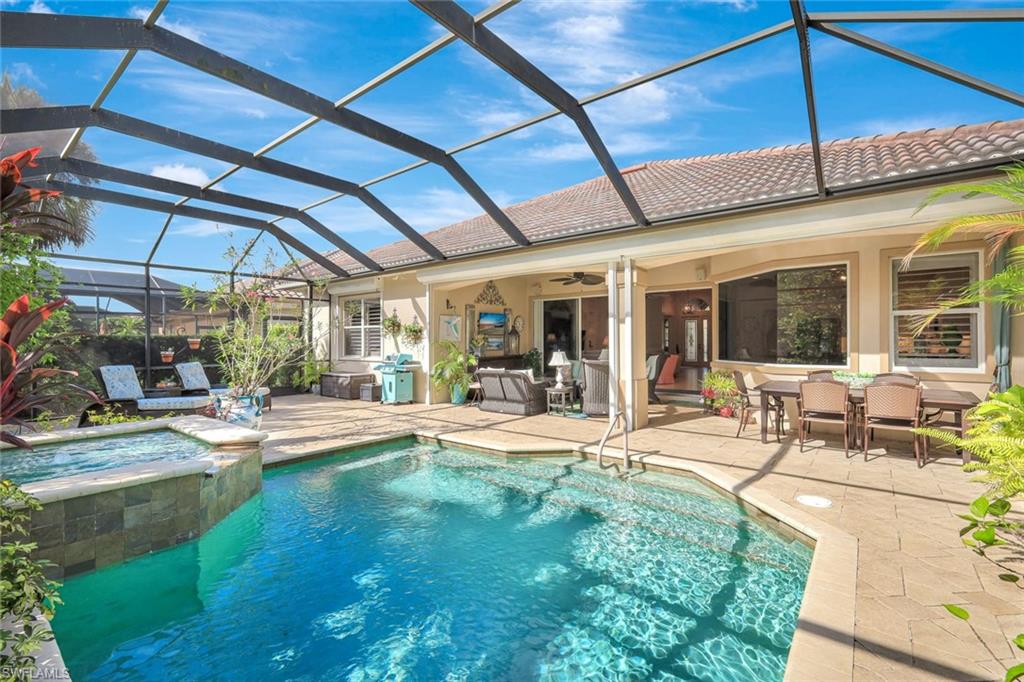 12441 Villagio Way Fort Myers, FL 33912 - Photo 28 of 32 a view of a backyard with table and chairs under an umbrella