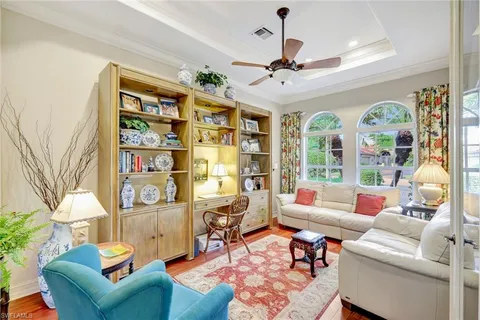 a living room with furniture a bookshelf and a large window