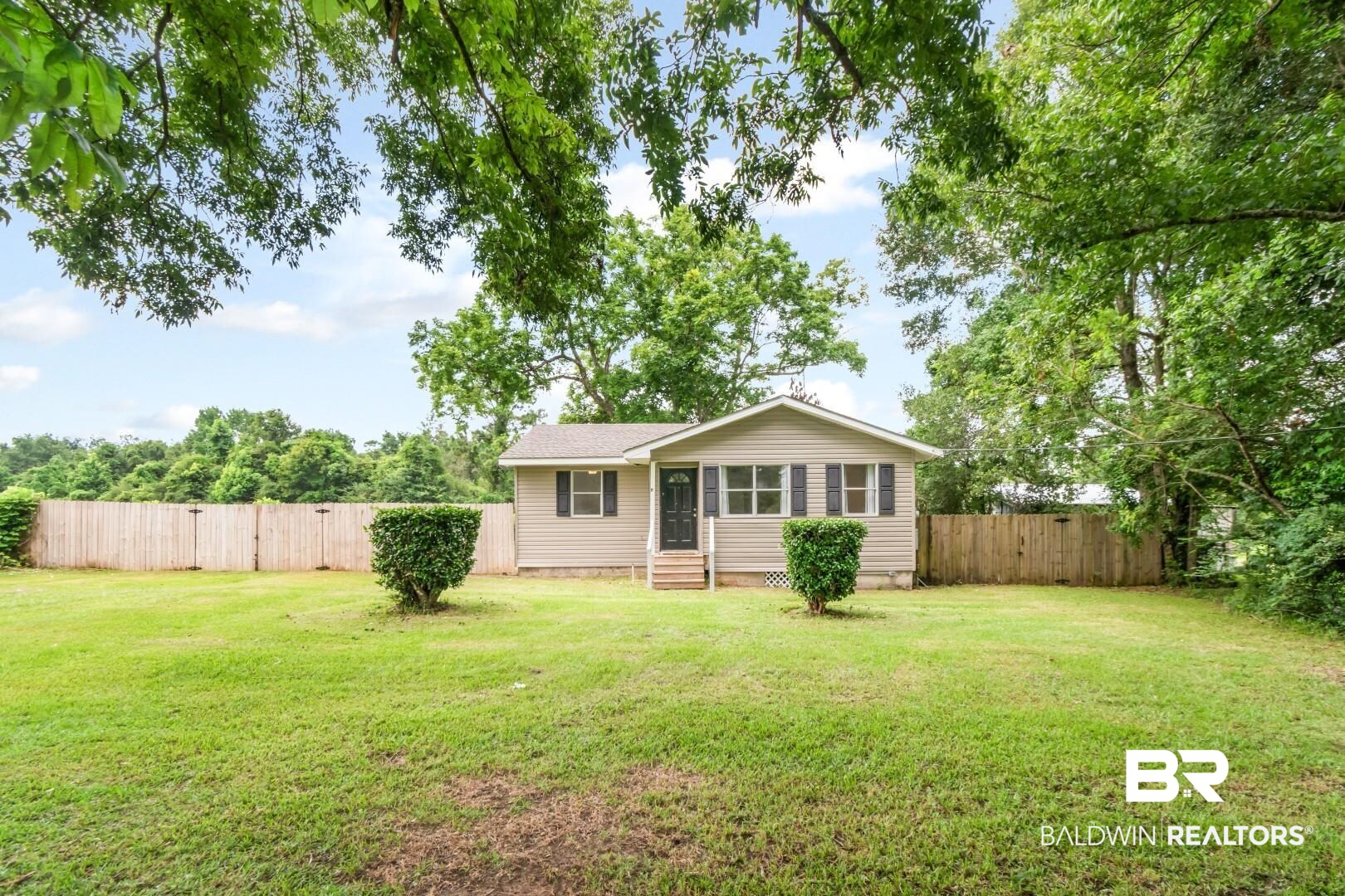 2905A McFarland Road, Unit F Mobile, AL 36695 - Photo 23 of 29 Fenced backyard featuring a manicured lawn, mature trees, and a light-colored siding exterior