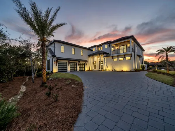 a front view of a house with a yard and lake view