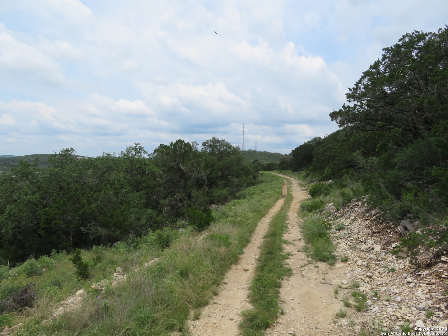0 Hilltop Loop Lakehills, TX 78063 - Photo 15 of 32 a view of a street with a yard and a wooden fence
