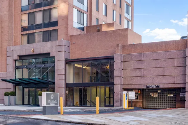 a front view of a building with glass windows and a street