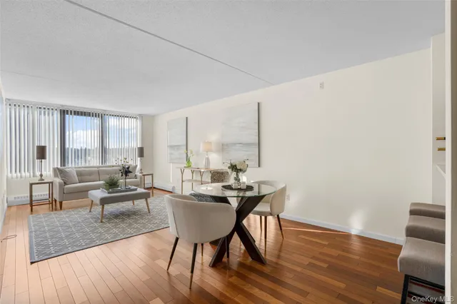 a living room with furniture a large window and wooden floor