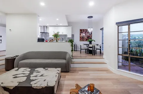 a living room with furniture and a dining table with kitchen view