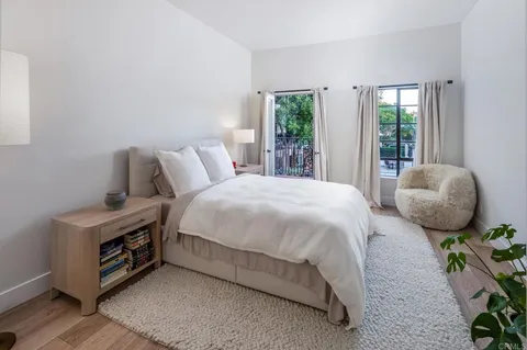 a bedroom with a bed and large windows