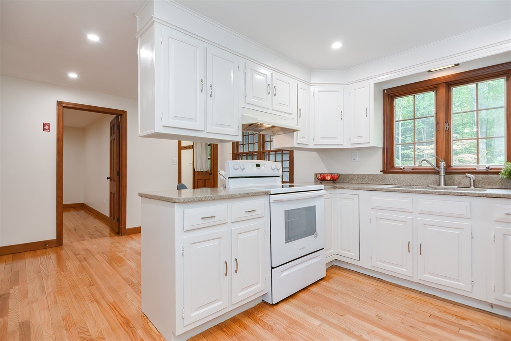156 Wheeler Road Hollis, NH 03049 - Photo 13 of 42 a kitchen with white cabinets and wooden floor