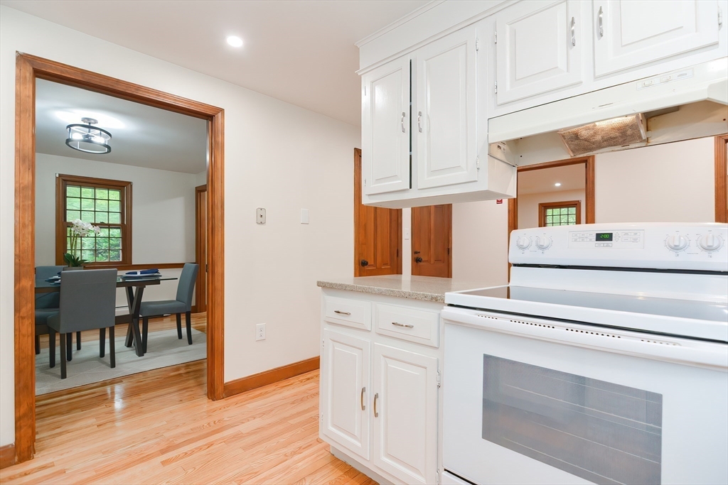 156 Wheeler Road Hollis, NH 03049 - Photo 14 of 42 a kitchen with cabinets wooden floor and a dining table