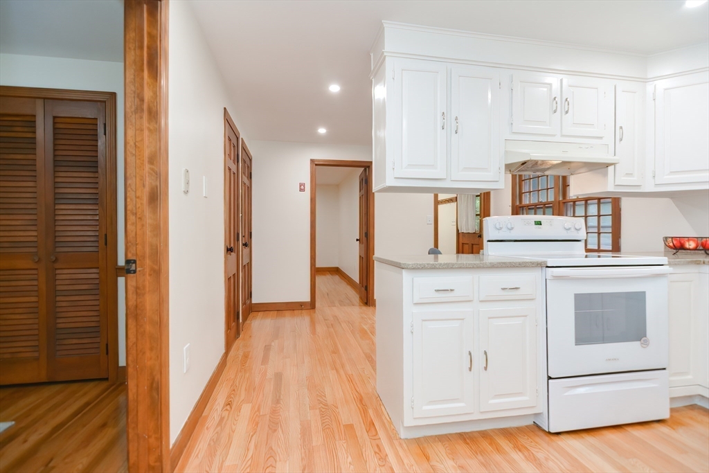 156 Wheeler Road Hollis, NH 03049 - Photo 23 of 42 a kitchen with cabinets oven and a dishwasher with wooden floor