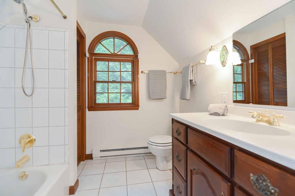 156 Wheeler Road Hollis, NH 03049 - Photo 38 of 42 a bathroom with a sink a toilet a mirror a vanity and window