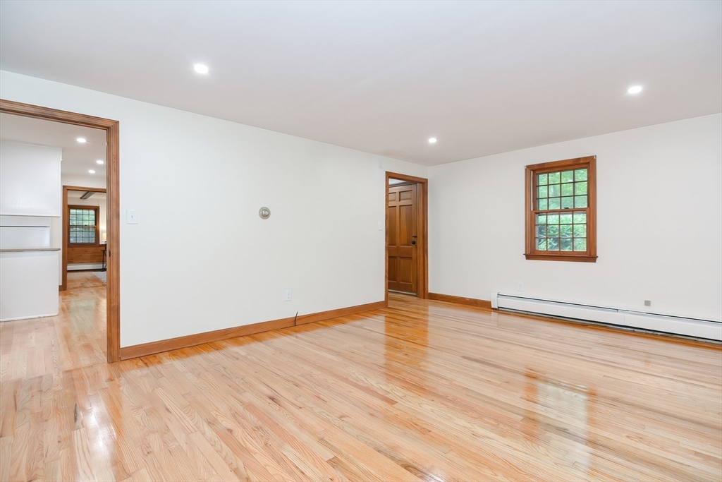 156 Wheeler Road Hollis, NH 03049 - Photo 7 of 42 a view of an empty room with wooden floor and a window