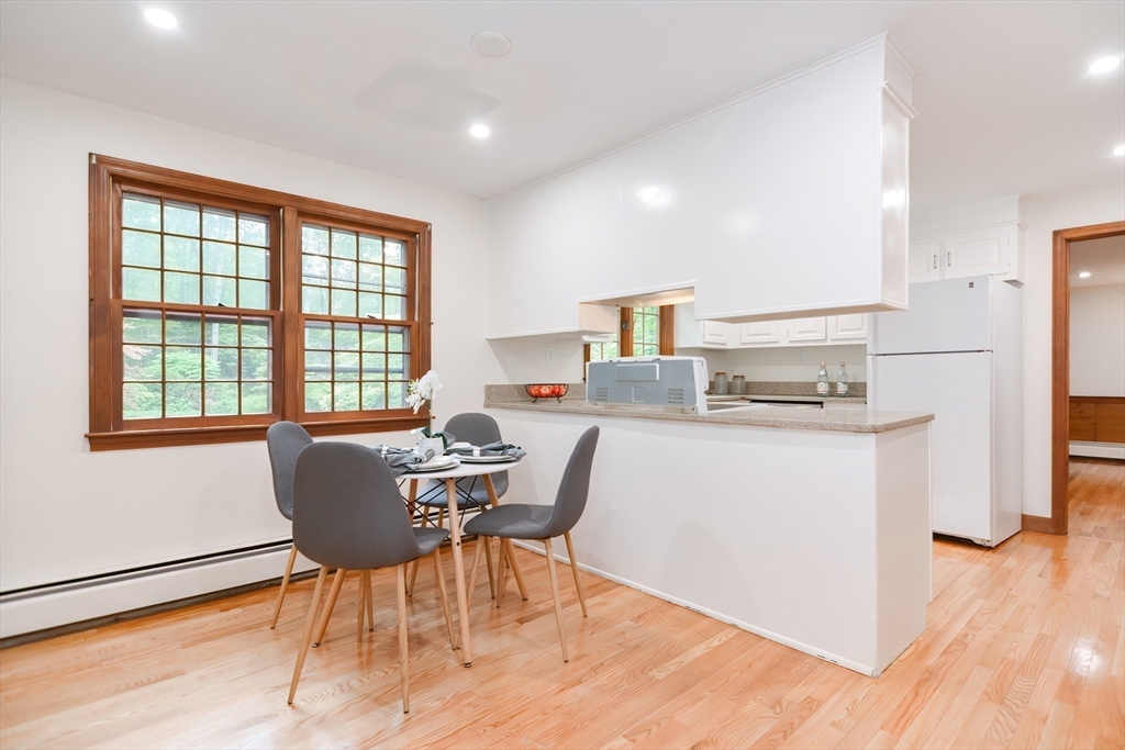 156 Wheeler Road Hollis, NH 03049 - Photo 8 of 42 a kitchen with a table chairs refrigerator and microwave
