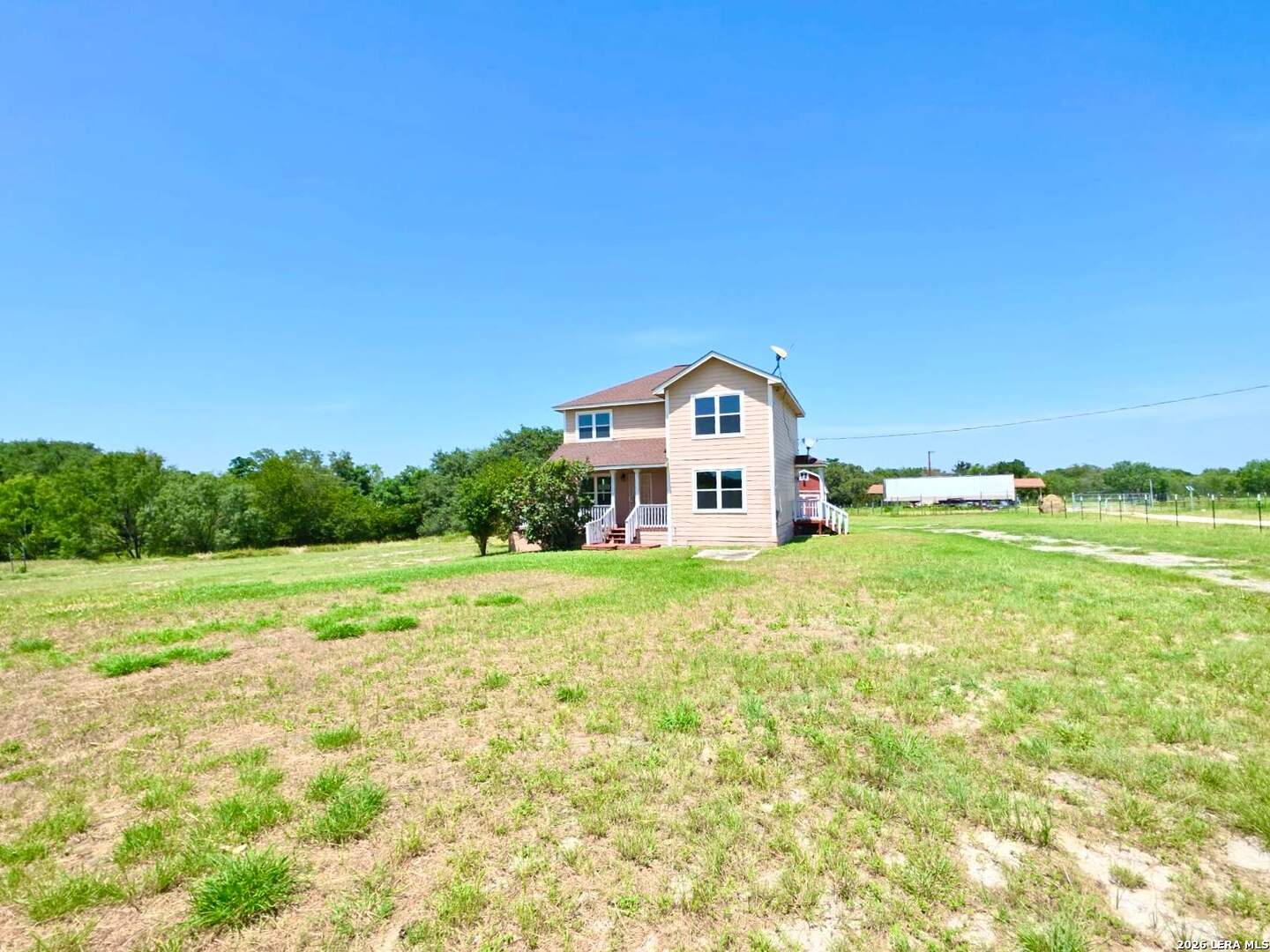 15506 Wheeler Road, Unit 4 Atascosa, TX 78002 - Photo 2 of 23 a view of a big house with a big yard and large trees