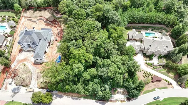 an aerial view of residential house with outdoor space and trees all around