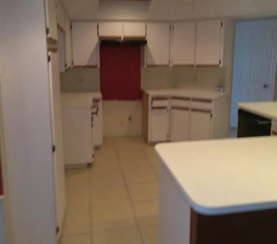 a kitchen with a refrigerator and cabinets