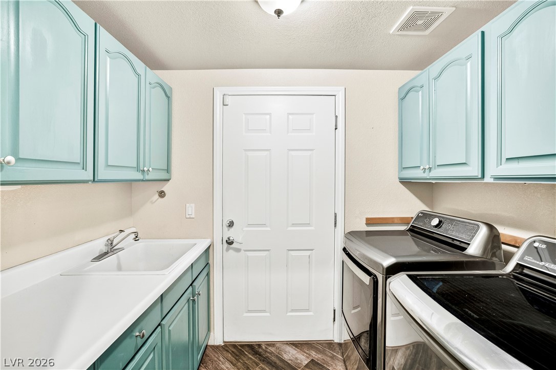 1135 Calico Ridge Drive Henderson, NV 89011 - Photo 28 of 86 Functional laundry room featuring a utility sink and ample storage in overhead cabinetry.