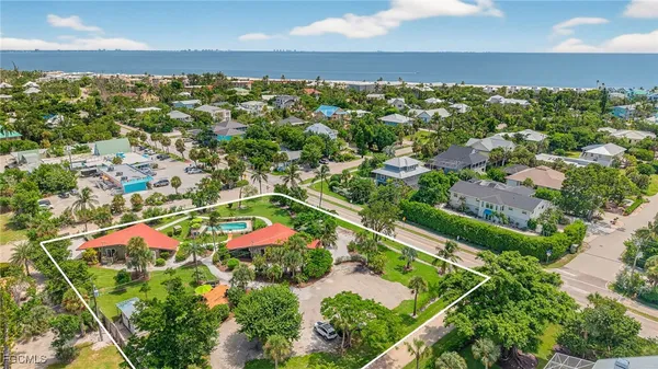 an aerial view of residential houses with outdoor space and trees