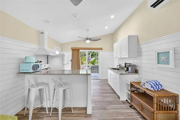 a large white kitchen with lots of counter space and windows