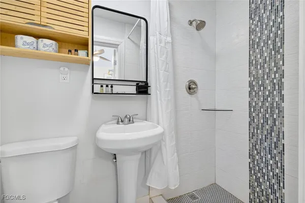 a bathroom with a sink a toilet and shower