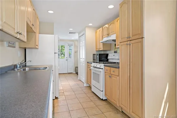a kitchen with a refrigerator and a stove top oven