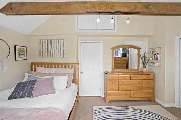 a bedroom with a bed and a painting on the wall