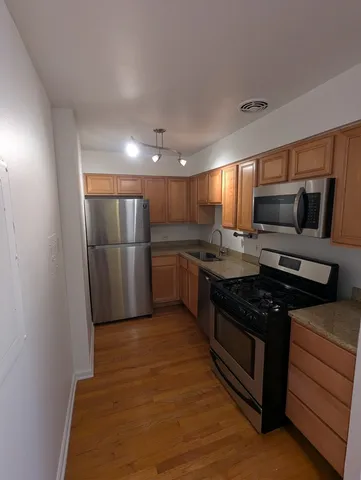 a kitchen with granite countertop a refrigerator and a stove top oven
