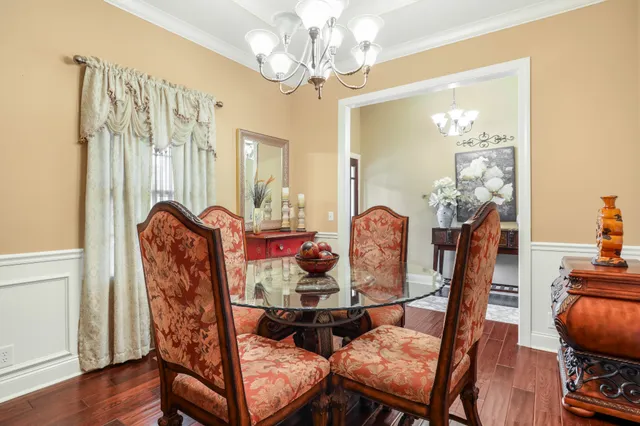 a dining room with furniture a chandelier and wooden floor