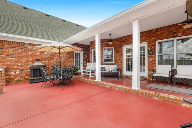 a view of a patio with a table and chairs under an umbrella