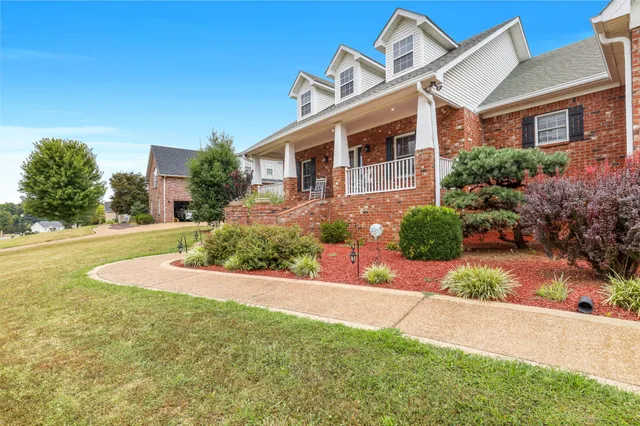 a front view of a house with a yard and trees