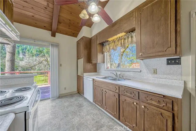 a kitchen with a sink appliances cabinets and a window